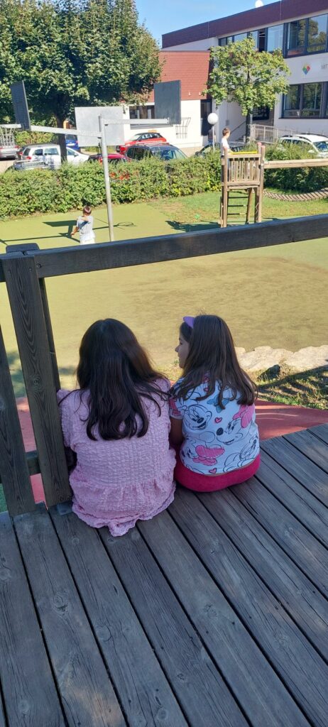 Kinder plaudern in der Hofpause bei schönem Wetter.