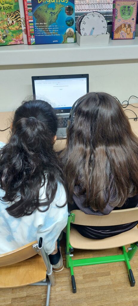 Zwei Kinder arbeiten mit der Anton-App am Computer. 