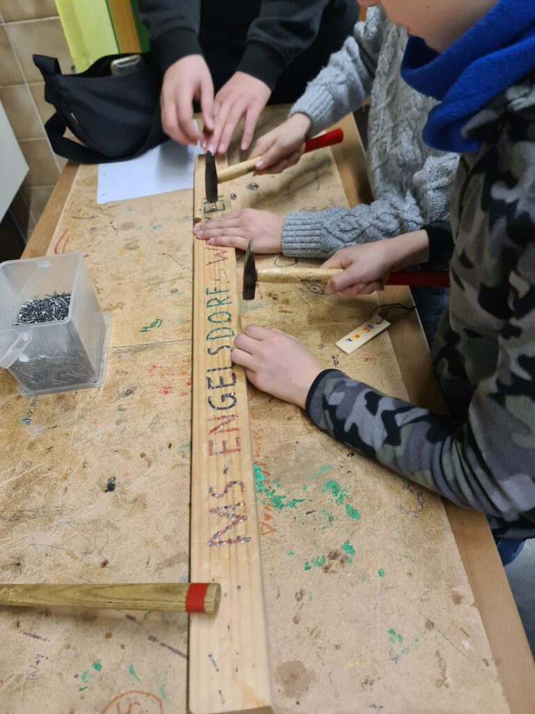 Kinder arbeiten mit Hammer und Nägel.