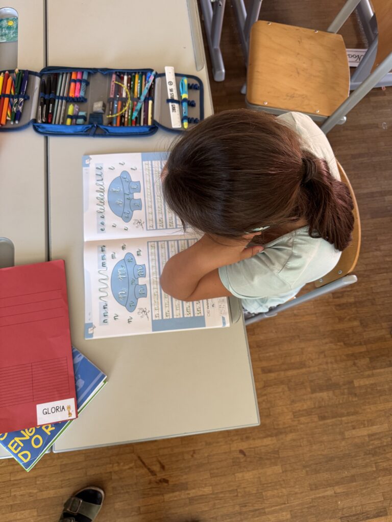 Ein Kind liest im Deutschbuch und füllt es aus. 