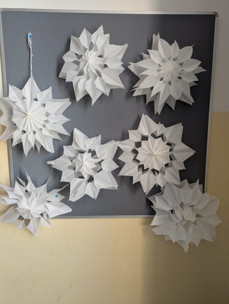 Weiße Papiersterne als Klassendekoration, diese sind im Kunstunterricht entstanden. 