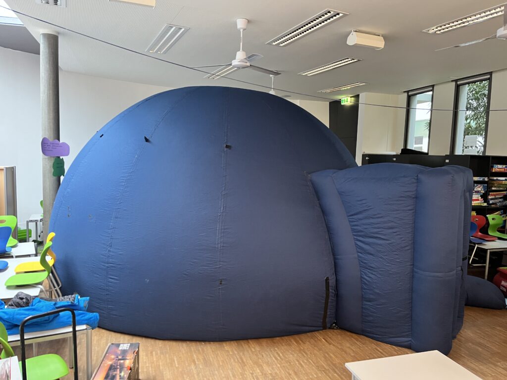 Aufblasbares blaues Planetarium im Festsaal der Schule. 