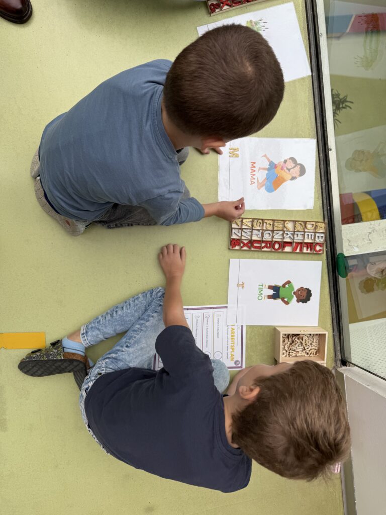 Ein Kind legt mit Buchstaben das Wort "Mama". 