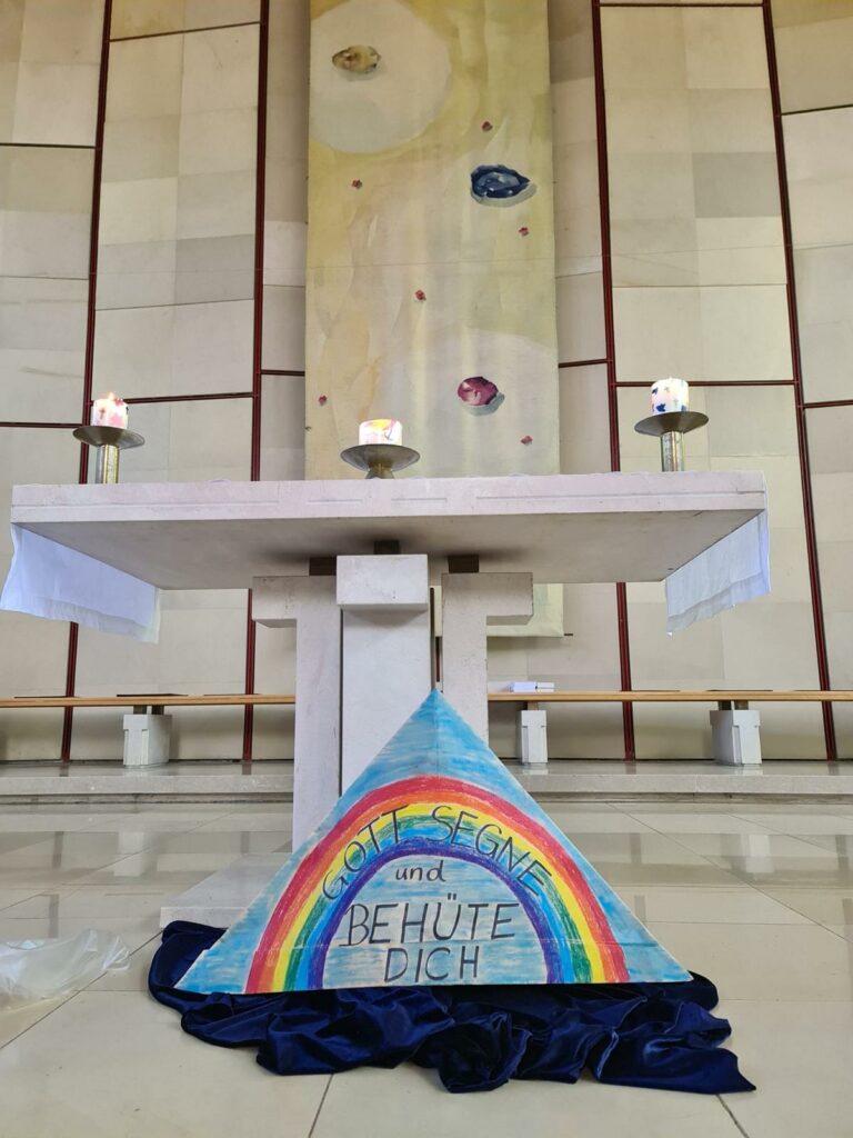 Im der Kirche Liebenau St. Paul feierte die Schule den Schulstart-Gottesdienst. Man sieht den Altar, davor liegt ein großer Hut aus Papier gefaltet. Darauf steht "Gott segne und behüte dich".