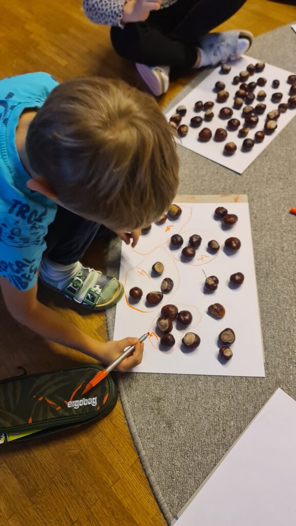 Kinder zählen Rosskastanien. Kreisen immer vier Kastanien ein. 