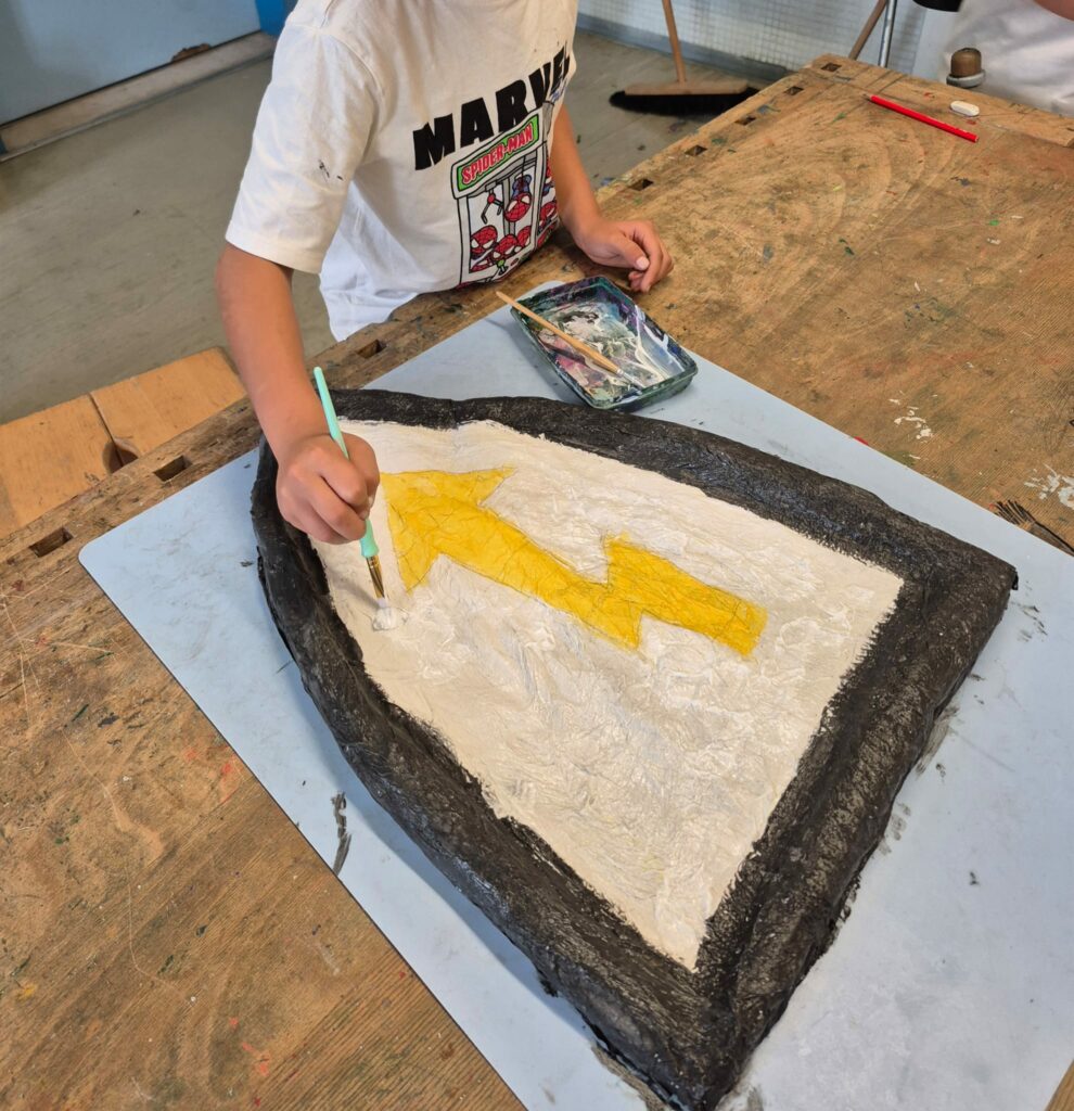 Ritterprojekt:
Kind gestaltet ein eigenes Ritterschild mit einem Blitz.
